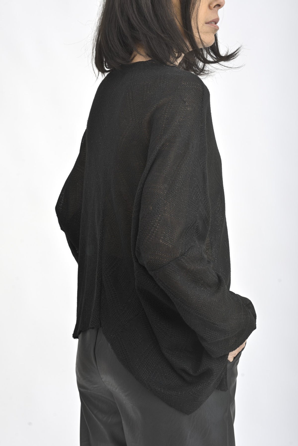 Vedere laterală a unei bluze asimetrice cu sclipici, mâneci lungi și design fluid