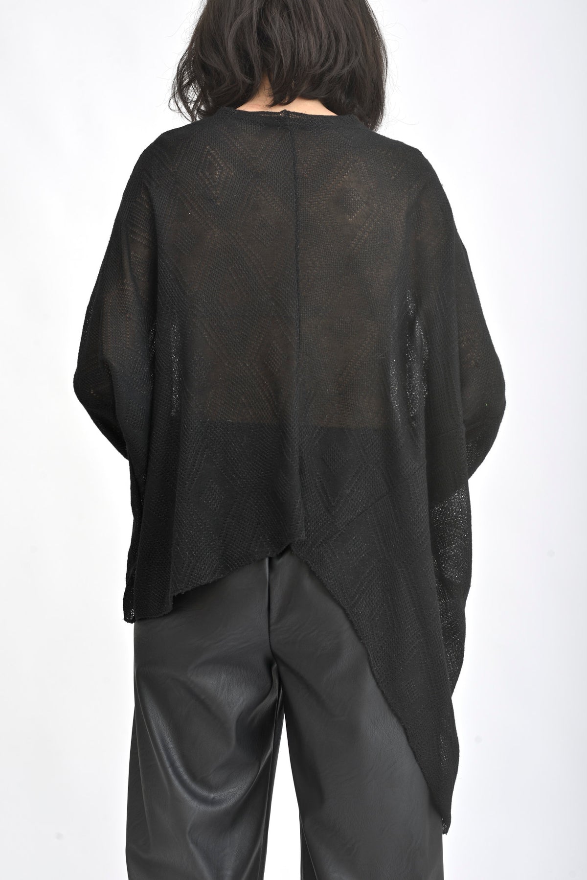 Vedere din spate a unei bluze asimetrice cu sclipici, croială amplă și lungime variabilă