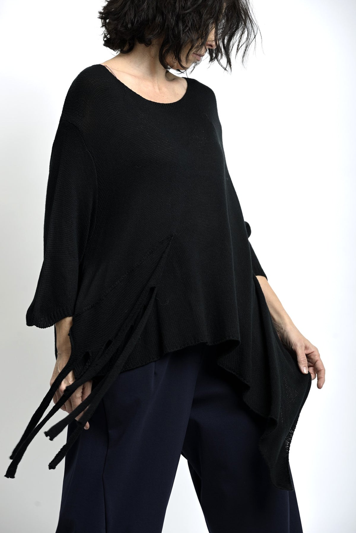 Bluză neagră cu colț asimetric și franjuri, croială amplă, stil boem și confortabil.