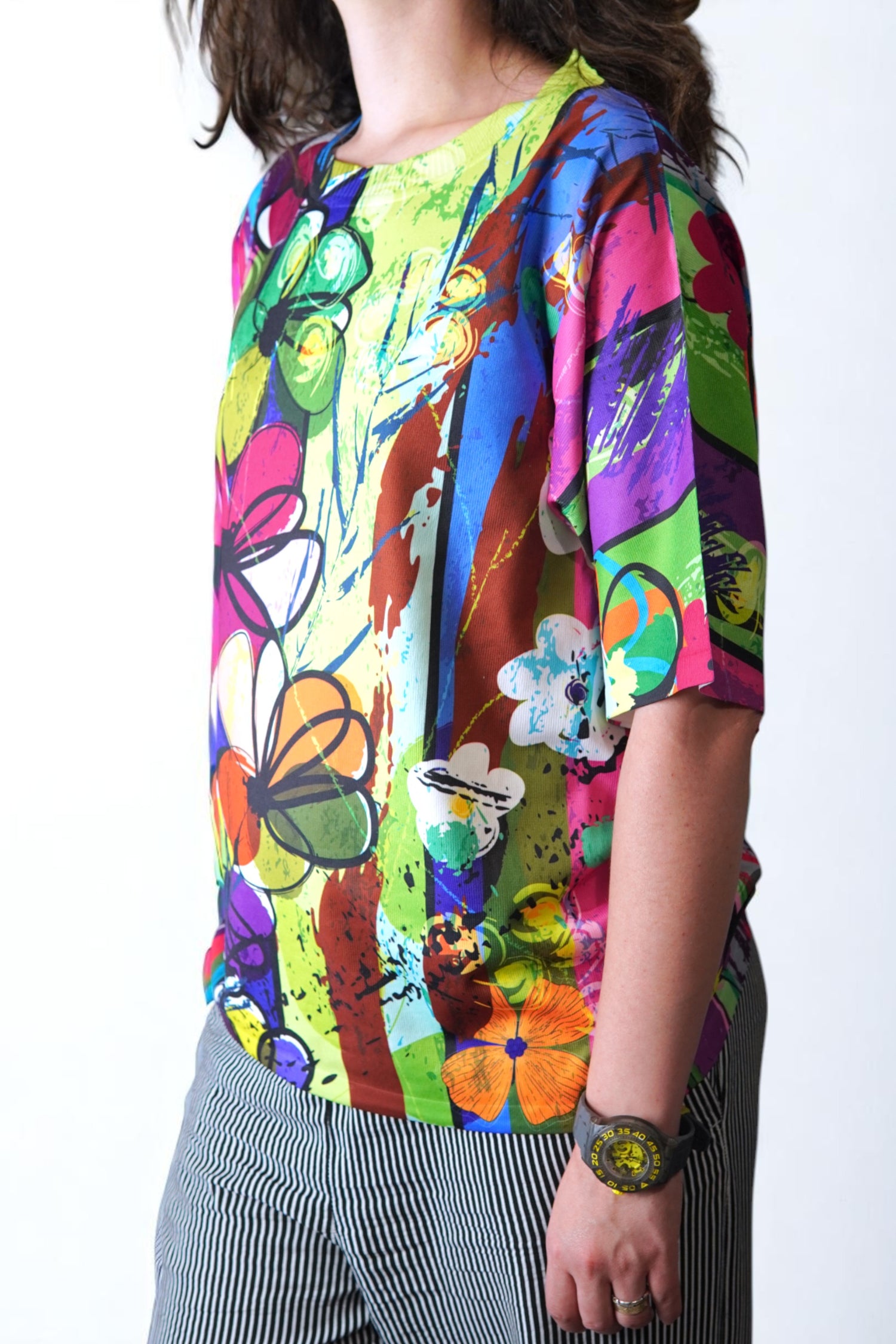 Detaliu lateral al bluzei cu imprimeu floral abstract, culori intense