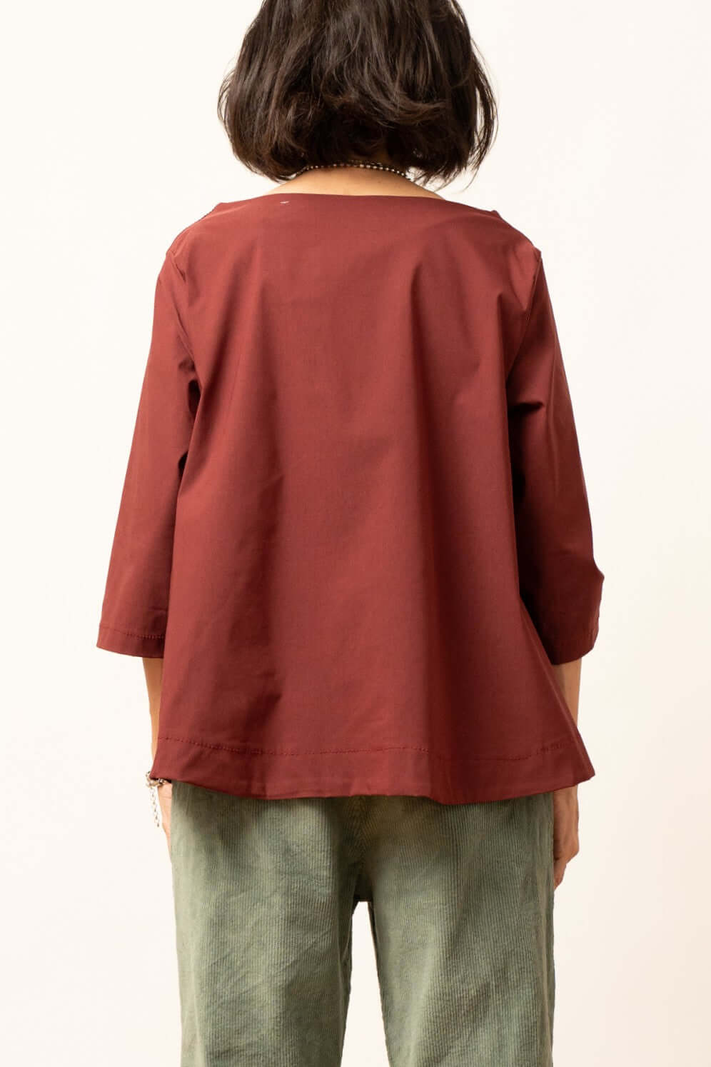 Bluza damă bordo văzută din spate, croială lejeră și mâneci trei sferturi.