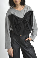 Detaliu bluză gri cu decolteu rotund și aplicație neagră tip fundă supradimensionată, stil urban elegant