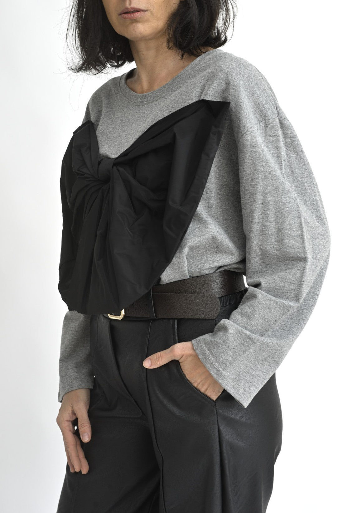 Vedere laterală a unei bluze gri din bumbac, cu aplicație decorativă neagră tip fundă și umeri căzuți