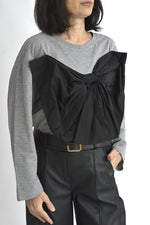 Bluză gri cu mâneci lungi și fundă neagră voluminoasă aplicată pe piept, look modern și statement