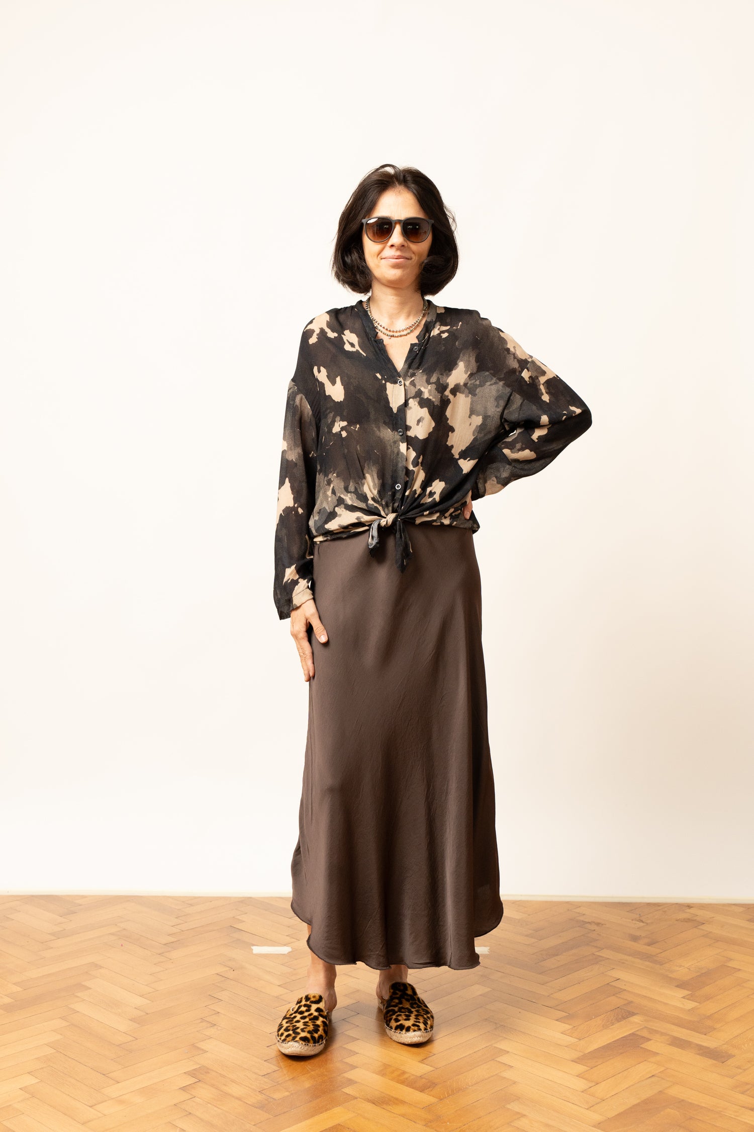 Bluza cu imprimeu abstract în nuanțe de negru și bej, purtată lejer, față.