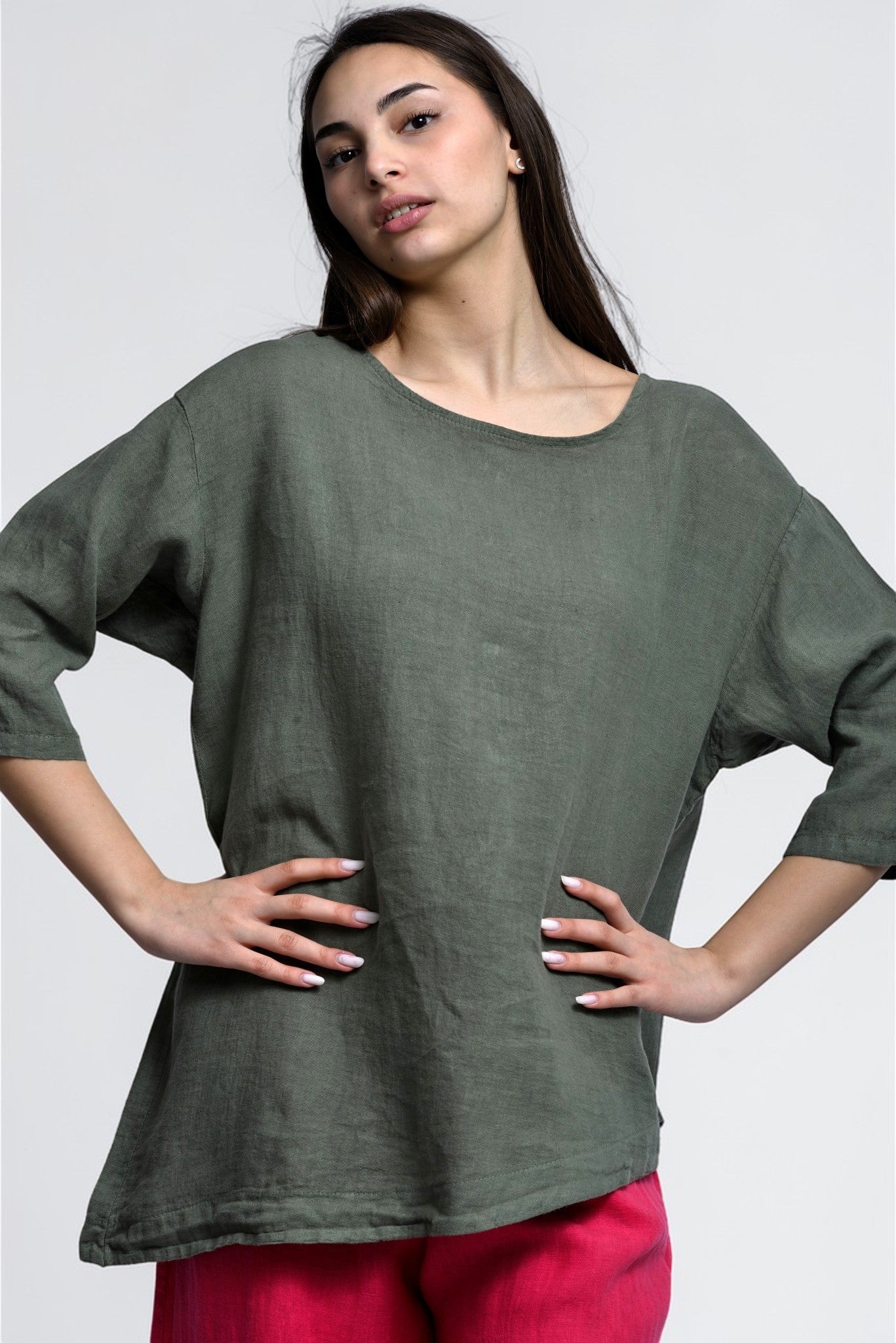 Model poartă bluză lejeră din in verde, cu umeri căzuți și linie fluidă, potrivită pentru ținute casual.