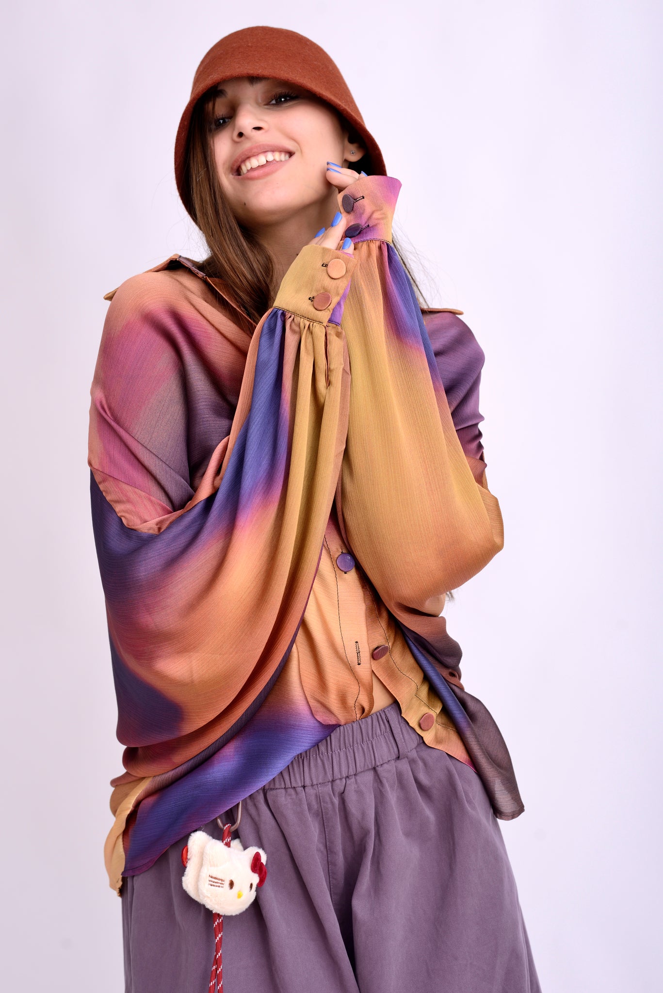 Detaliu mânecă largă a bluzei kaftan din material vaporos, cu imprimeu artistic în culori calde.