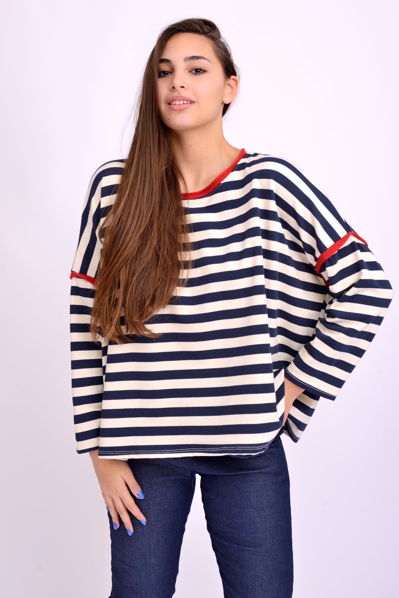 Bluză largă navy cu dungi albe și detalii roșii la umeri, purtată pe model, croială lejeră cu umeri căzuți.