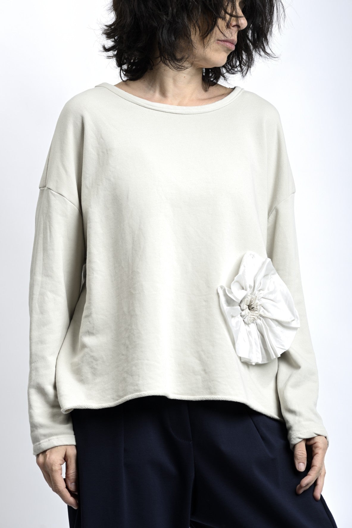 Bluză largă din jerse de bumbac, cu croială rândunică și aplicație floare la bază, în nuanță deschisă.