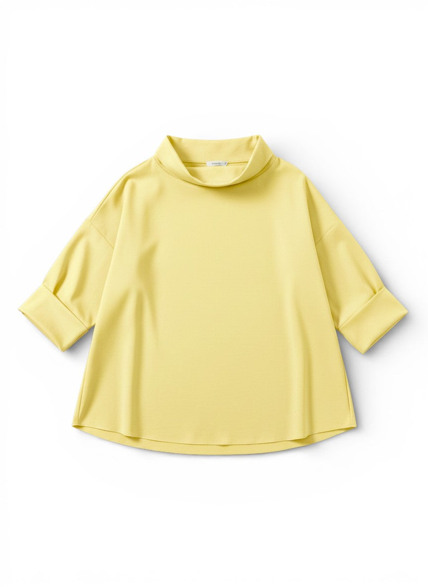 Bluză galben pastel cu guler larg și umeri căzuți, evidențiind proporțiile lejere.
