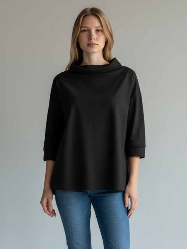 Ținută cu bluză neagră cu guler amplu și croială relaxată, stil casual de zi.