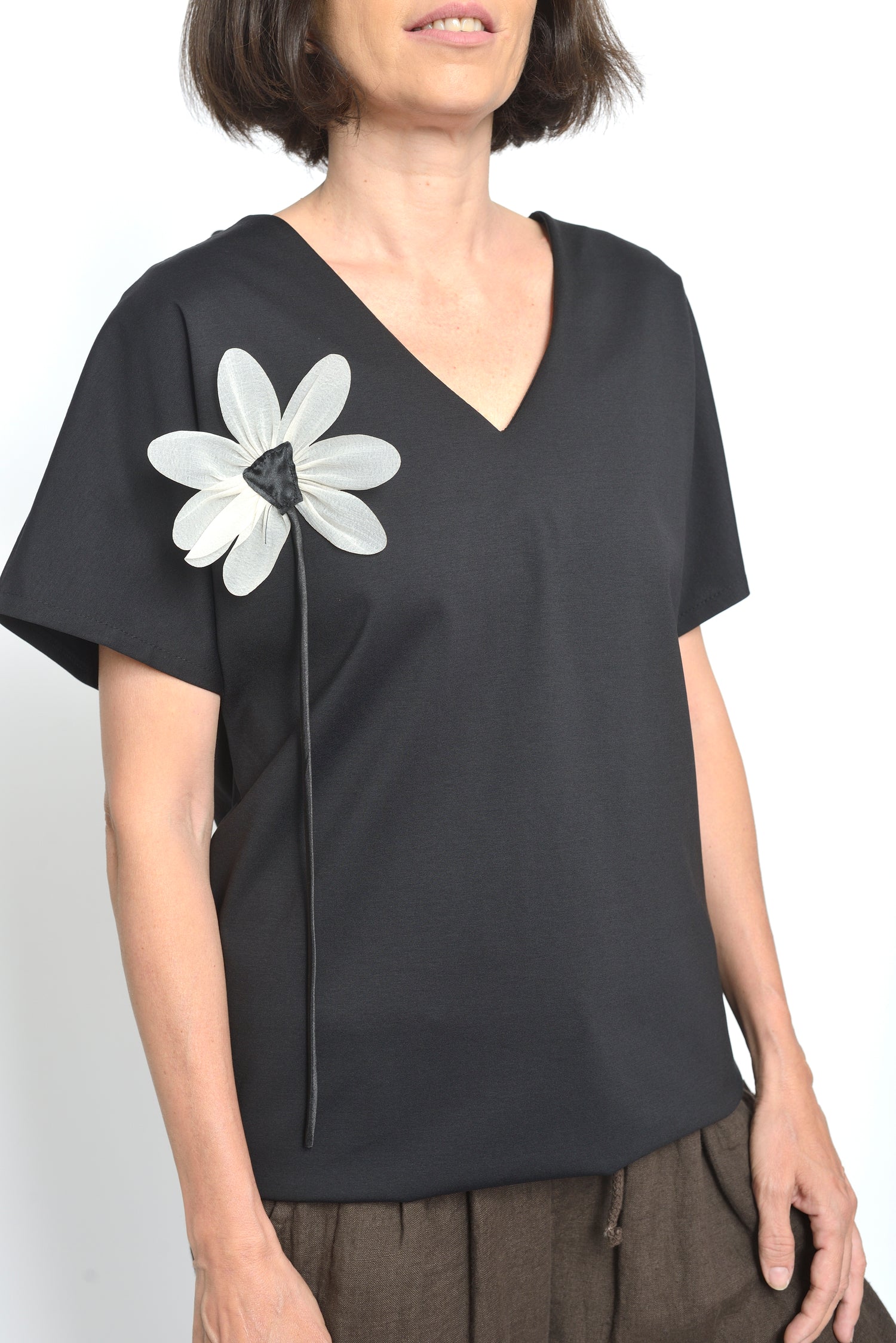 Bluza din bumbac cu mânecă scurtă și detaliu floral alb pe fond negru.