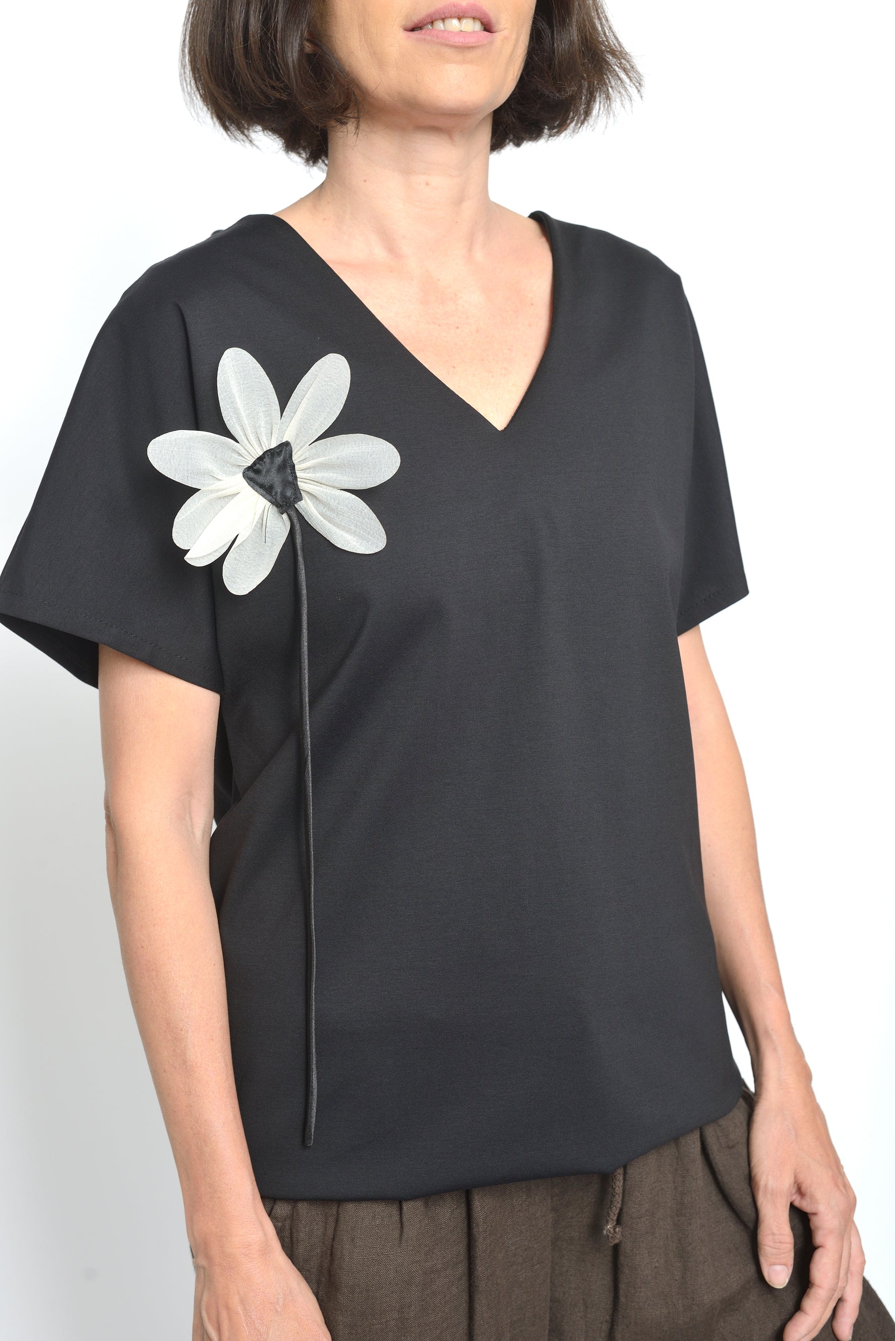 Bluza din bumbac cu mânecă scurtă și detaliu floral alb pe fond negru.