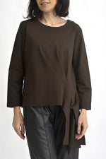 Detaliu bandă laterală decorativă a unei bluze maro, cu finisaj fluid și aspect elegant