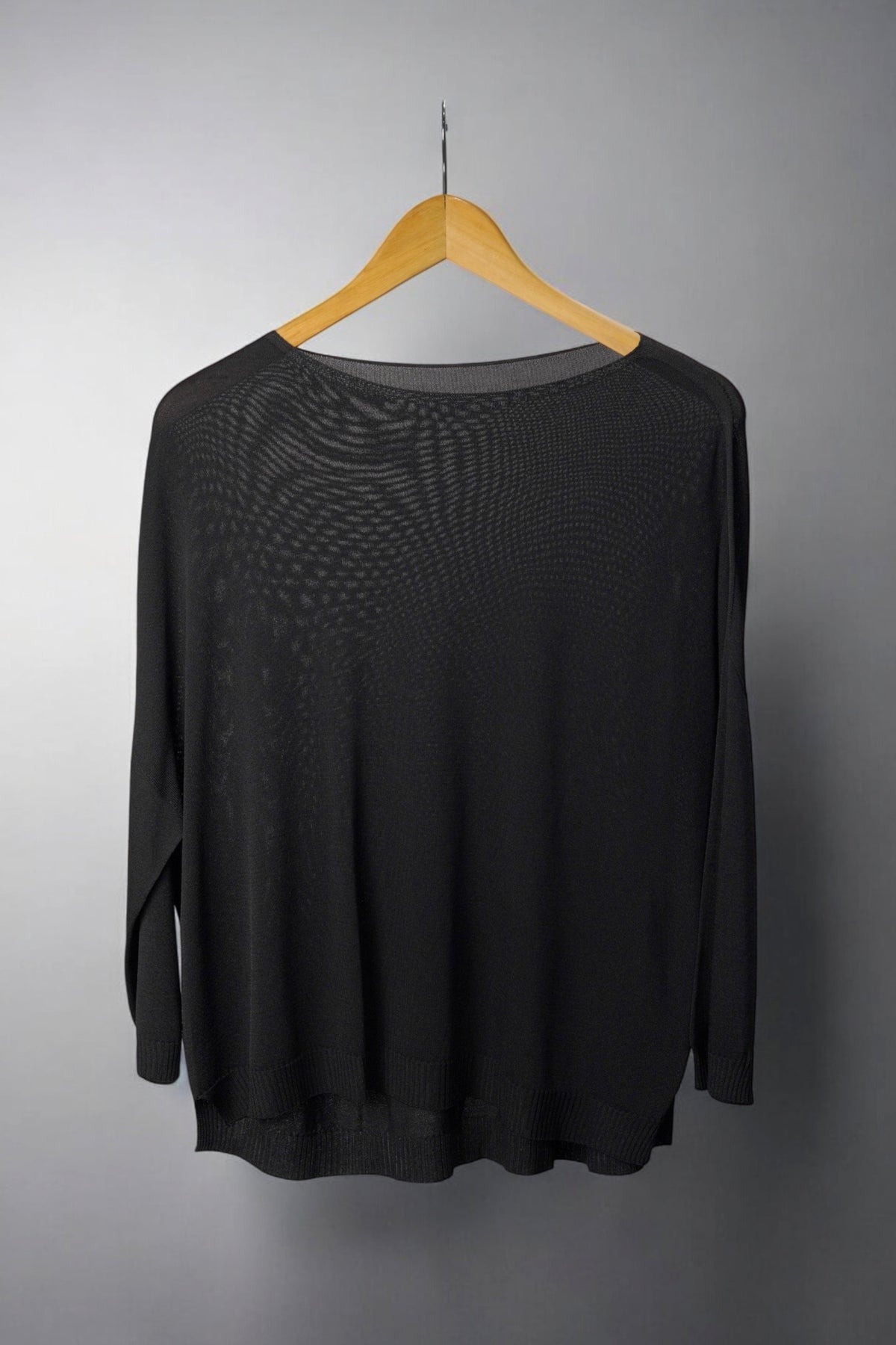  Bluza neagră largă, semi-transparentă, cu croială lejeră și tiv ușor asimetric.