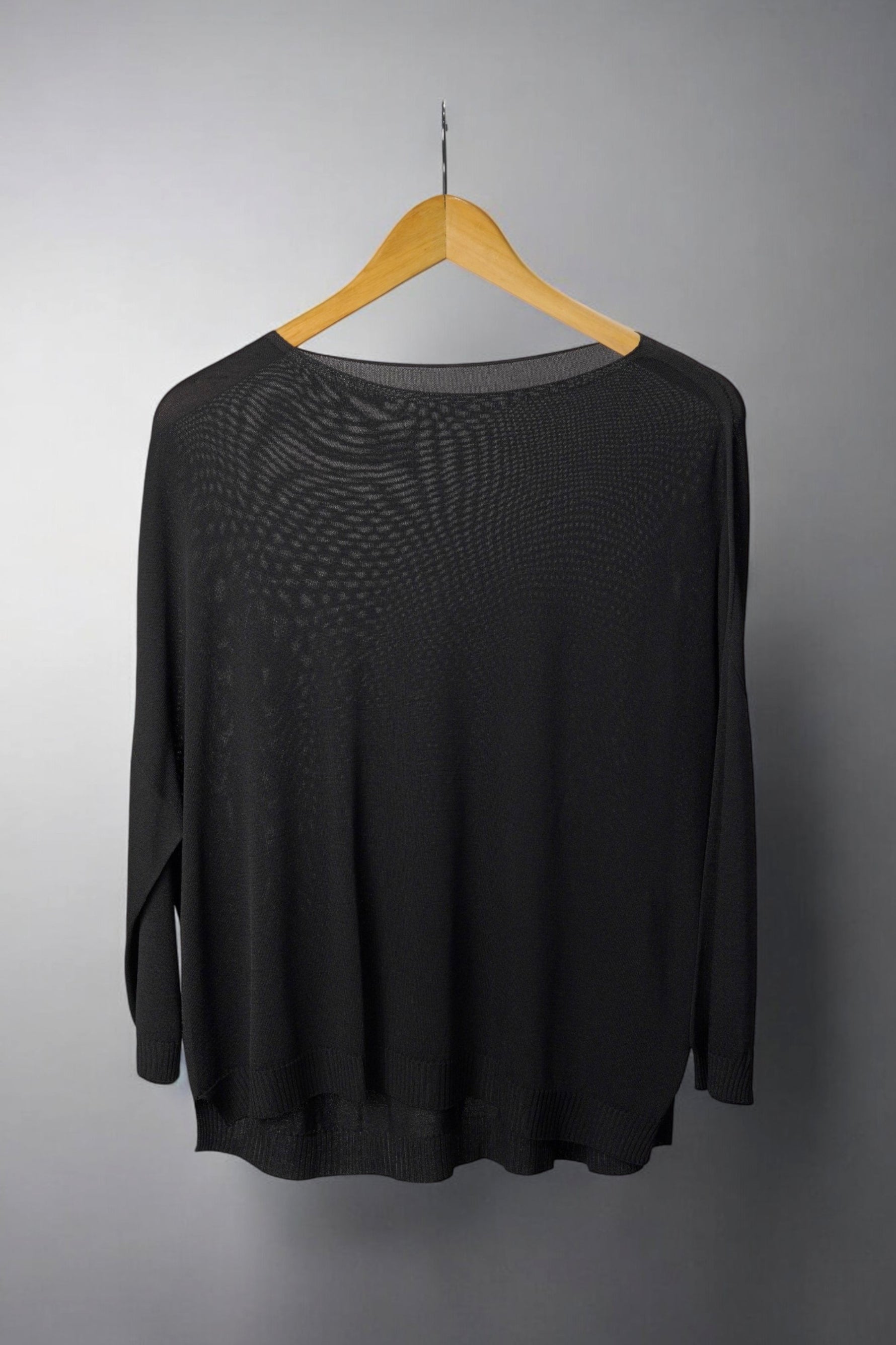  Bluza neagră largă, semi-transparentă, cu croială lejeră și tiv ușor asimetric.