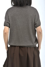 Vedere din spate a unei bluze cu sclipici, croială amplă și lungime medie