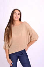 Bluză aurie din tricot cu sclipici fin, croială lejeră și umeri căzuți, purtată pe model.