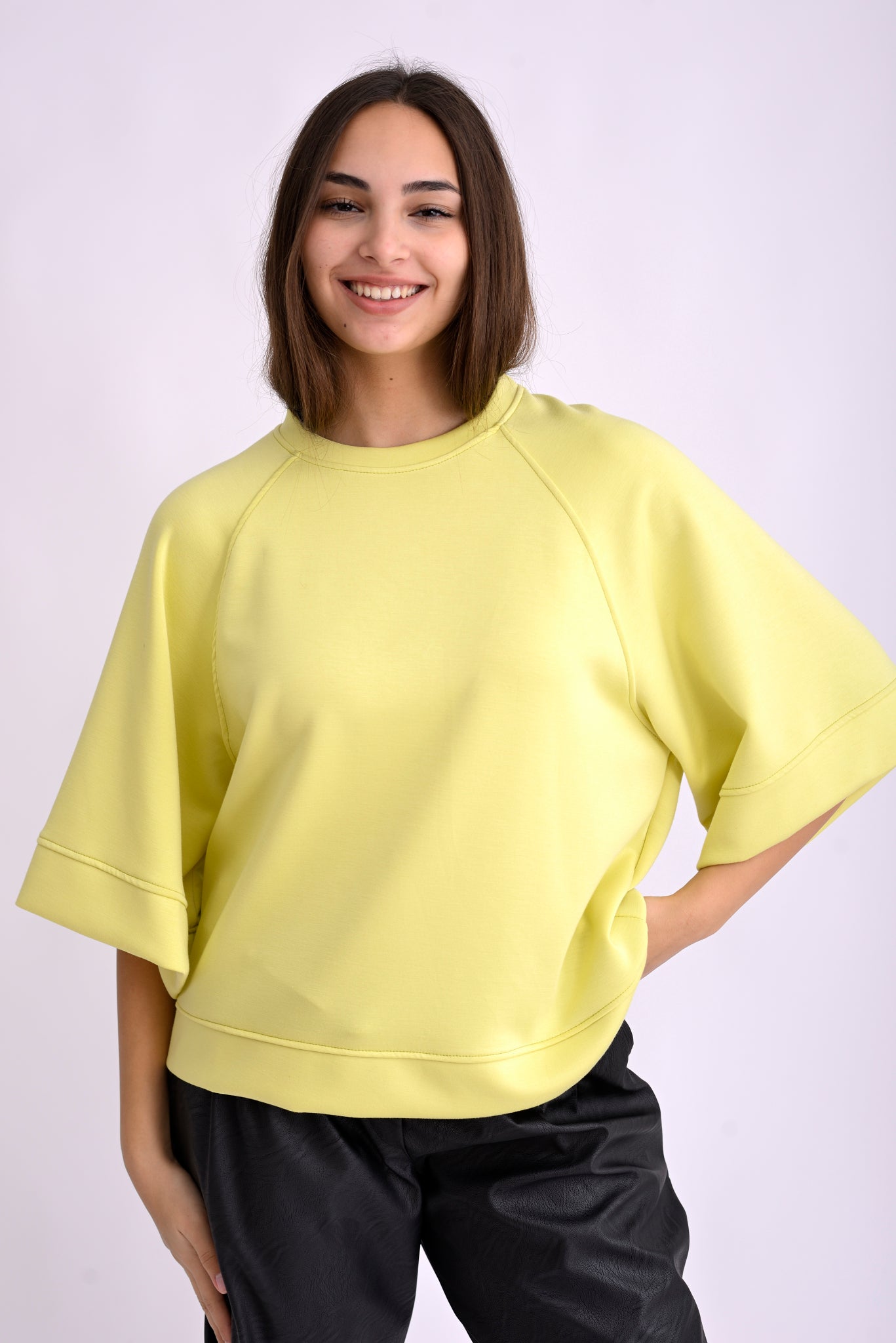 Bluză top galbenă cu mânecă trei sferturi și croială lejeră, din material moale, purtată pe model, vedere frontală.