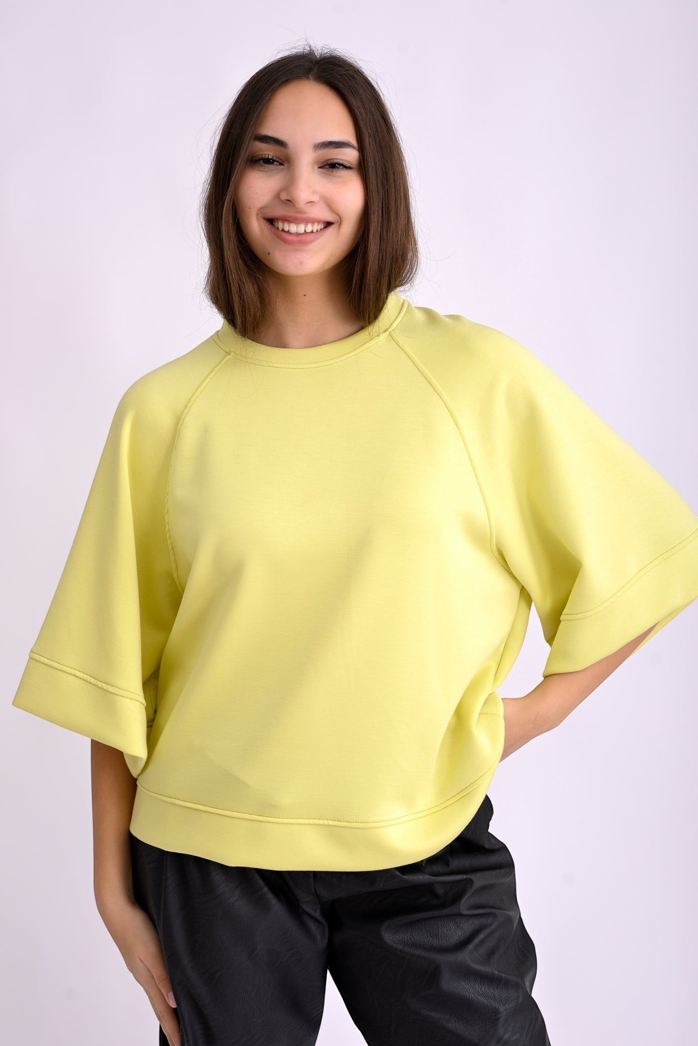 Bluză top galbenă cu mânecă trei sferturi și croială lejeră, din material moale, purtată pe model, vedere frontală.