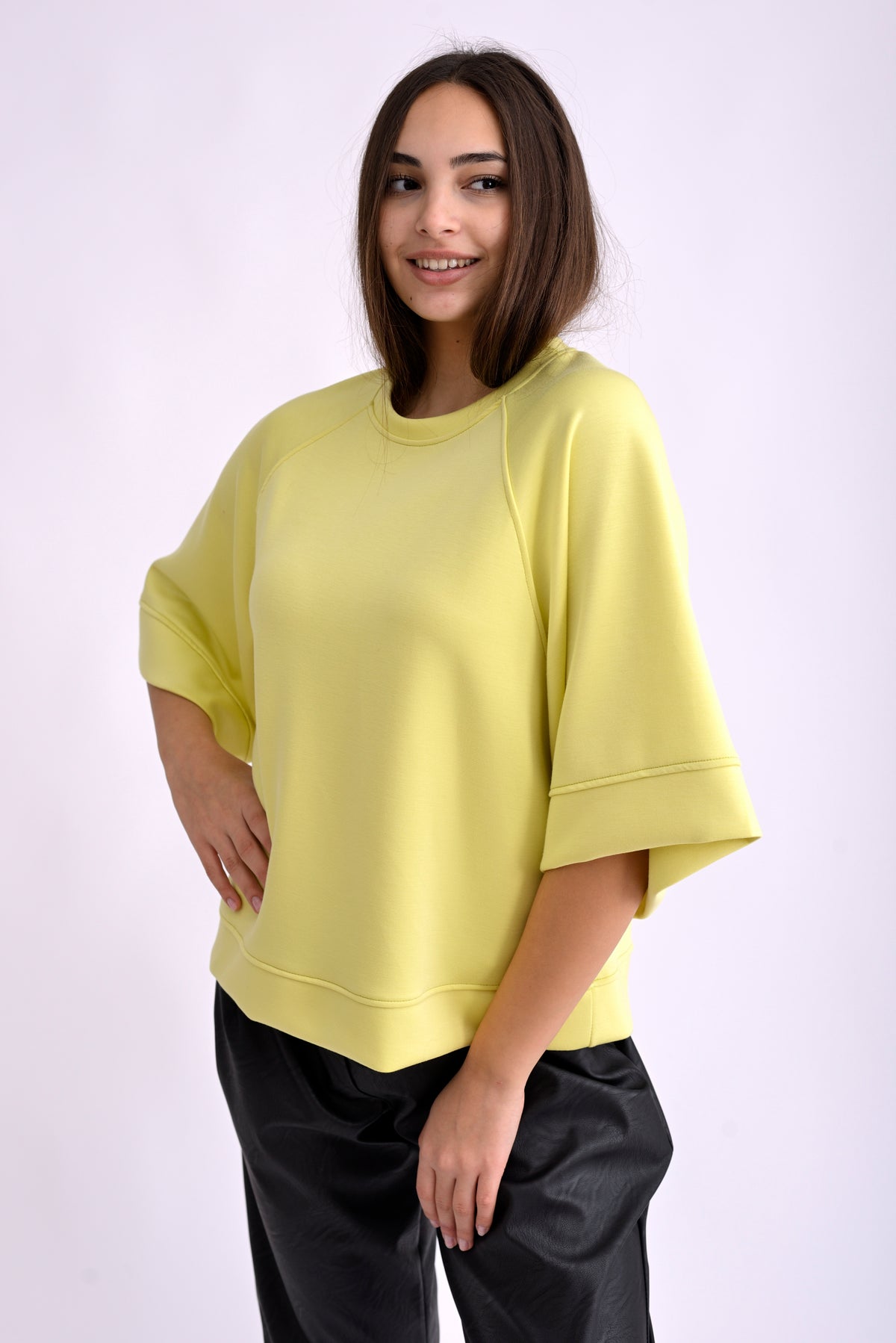 Bluză galbenă lejeră cu mâneci trei sferturi și croială oversize, vedere din spate pe model.