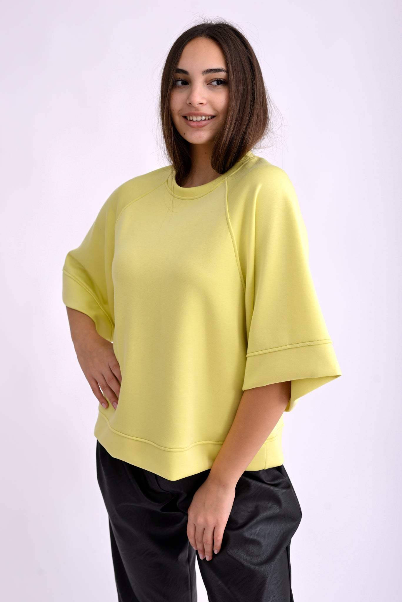 Bluză galbenă lejeră cu mâneci trei sferturi și croială oversize, vedere din spate pe model.