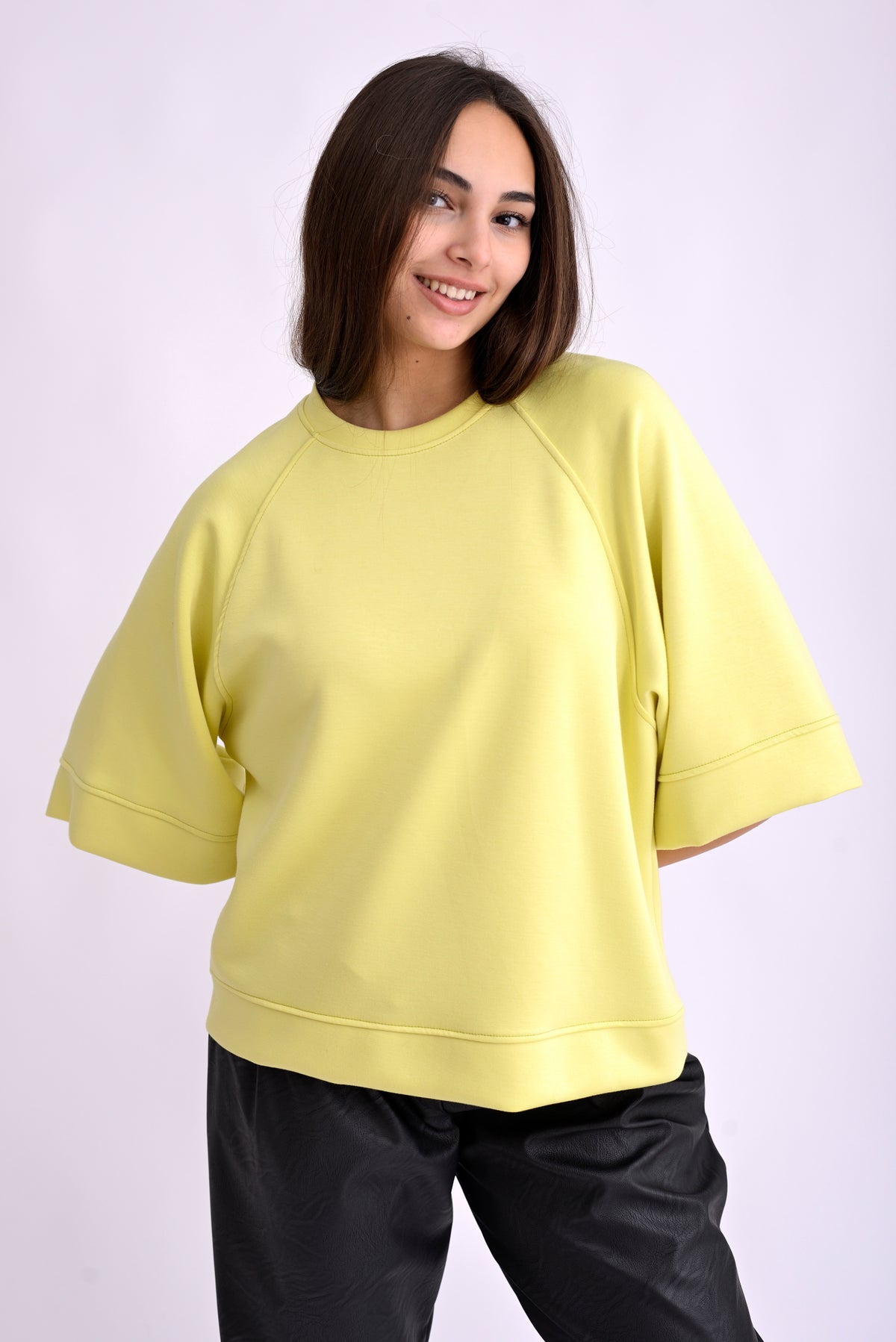 Top galben cu mânecă trei sferturi, umeri căzuți și textură fină, vedere laterală pe model.