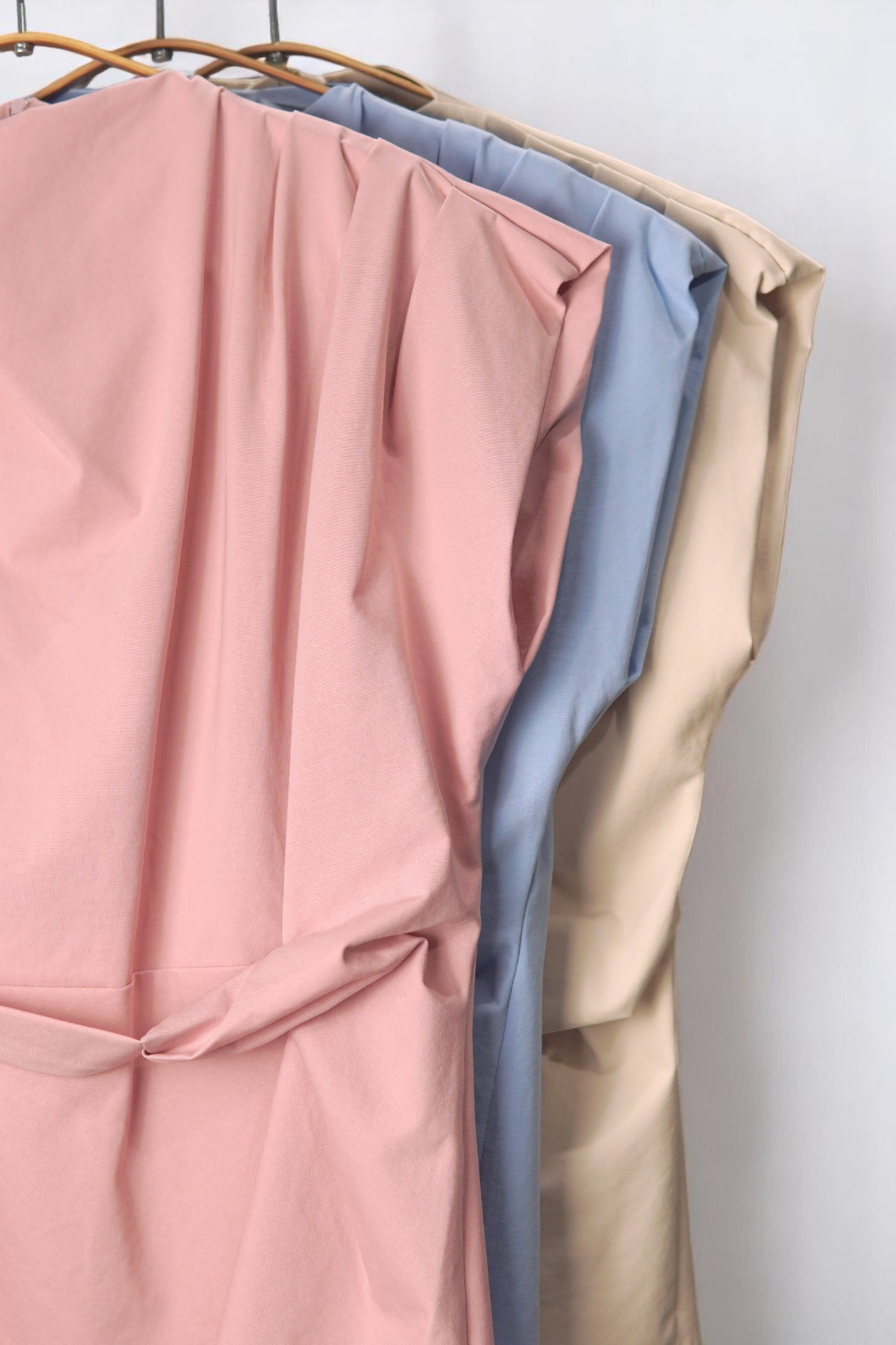 Detaliu material și croi pentru bluzele top cu centură, în culori pastel – roz, albastru și bej.