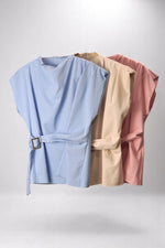 Bluză top cu turtleneck și centură, disponibilă în trei culori pastel – albastru, bej și roz pudrat, pe umeraș.