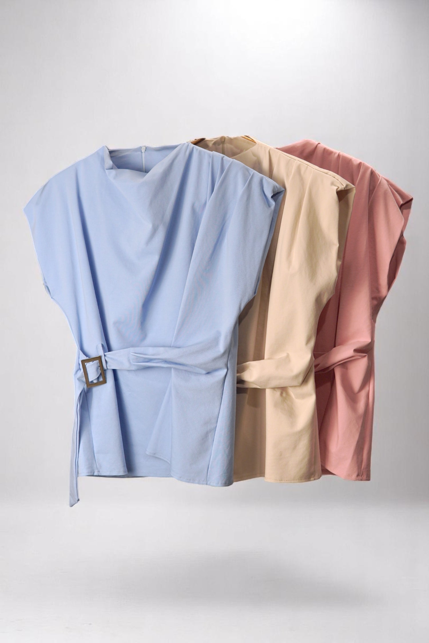 Bluză top cu turtleneck și centură, disponibilă în trei culori pastel – albastru, bej și roz pudrat, pe umeraș.