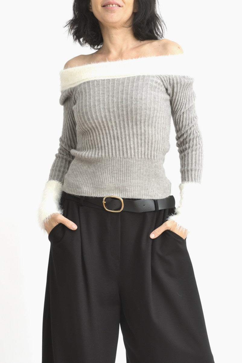 Vedere laterală a bluzei gri din tricot, cu umeri goi și mâneci lungi terminate cu manșete pufoase albe.