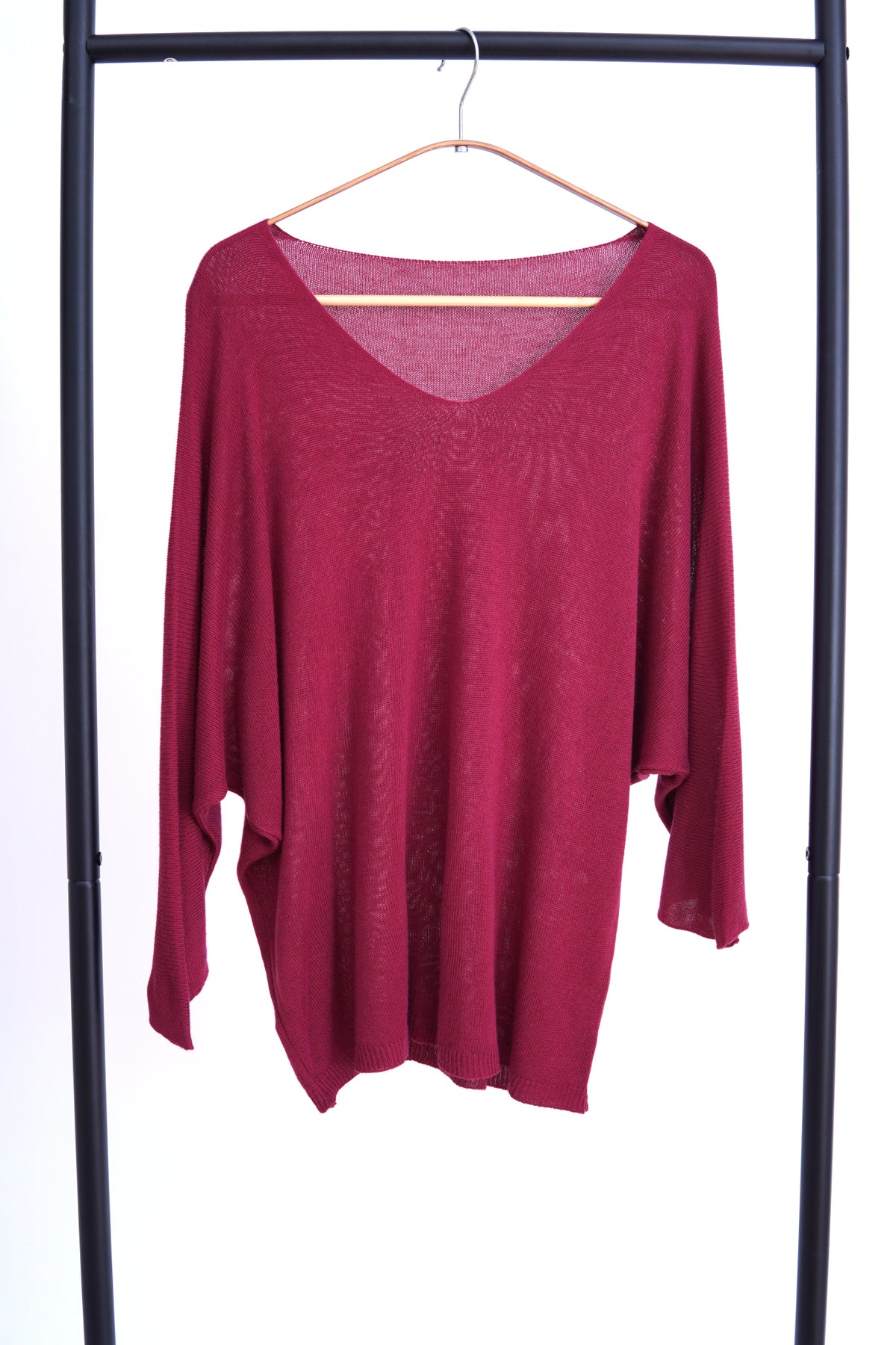  Bluză lejeră din tricot visinie, cu decolteu în V și mâneci trei sferturi, prezentată pe umeraș.