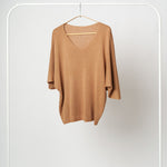 Bluza tricotată moale în nuanță camel, cu decolteu în V și mâneci trei sferturi, expusă pe umeraș alb.