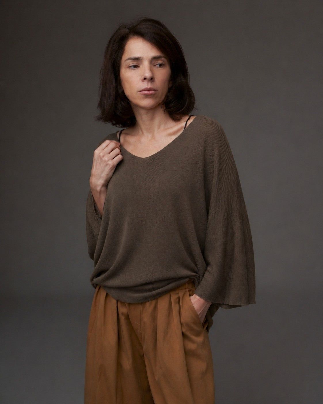 Femeie purtând bluza tricot cu decolteu în V, mâneci trei sferturi și croială lejeră.