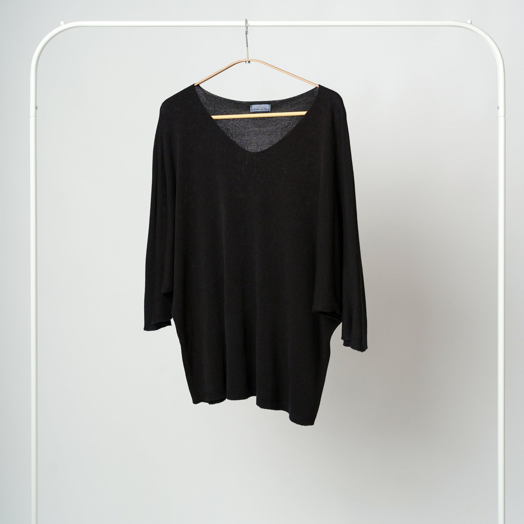 Bluza din tricot negru, ușor transparentă, cu croială amplă și decolteu adânc în V.