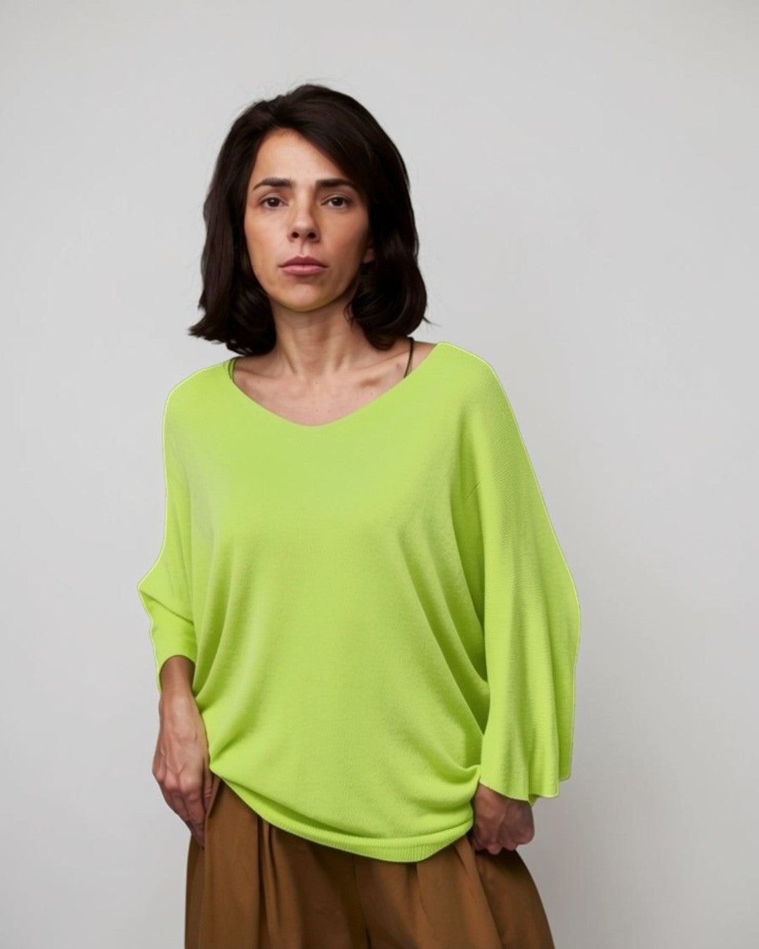 Femeie purtând bluza tricot cu decolteu în V, mâneci trei sferturi și croială lejeră.