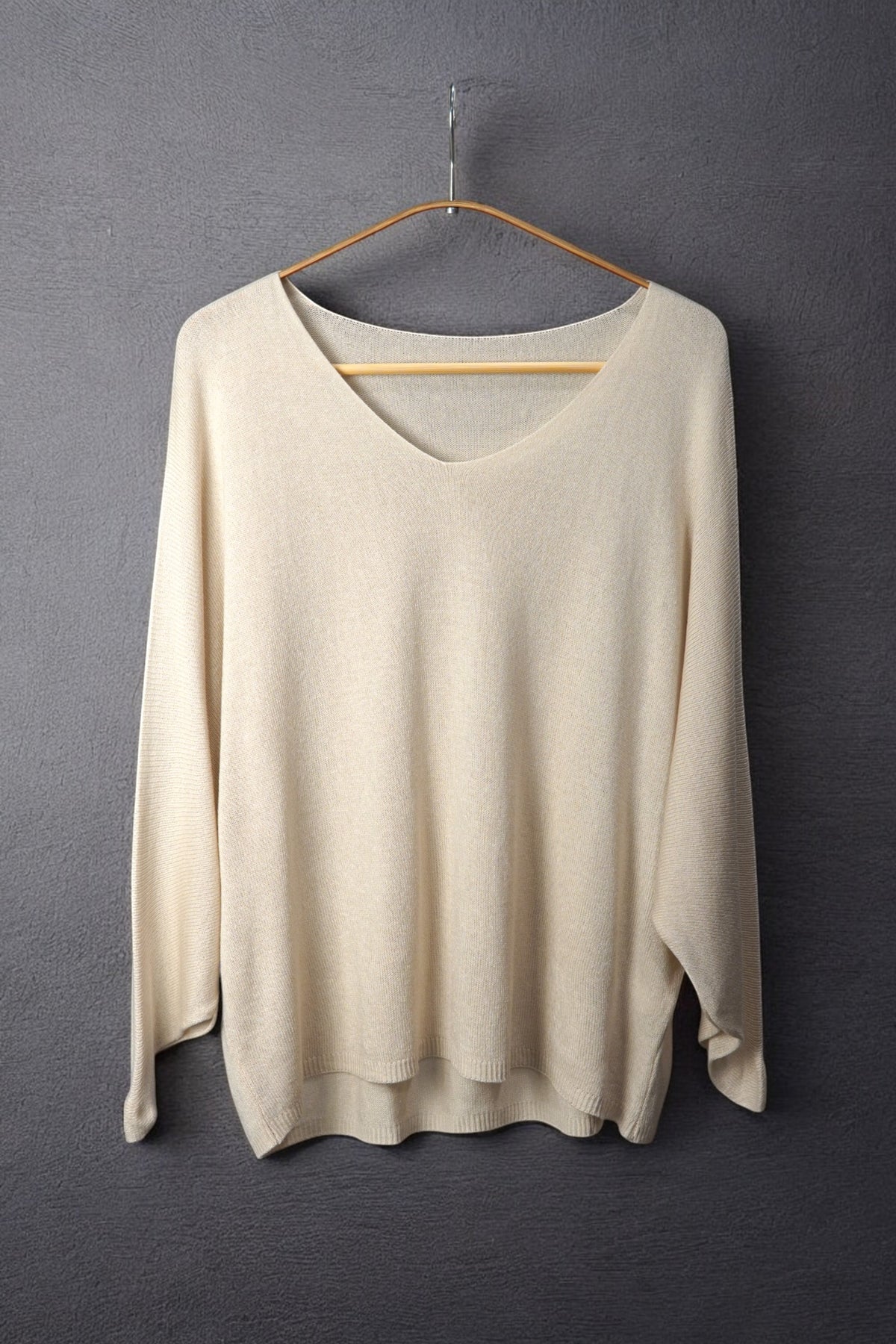 Bluză nude-bej din tricot fin, cu decolteu în V și croială vaporoasă, perfectă pentru un look soft și feminin.