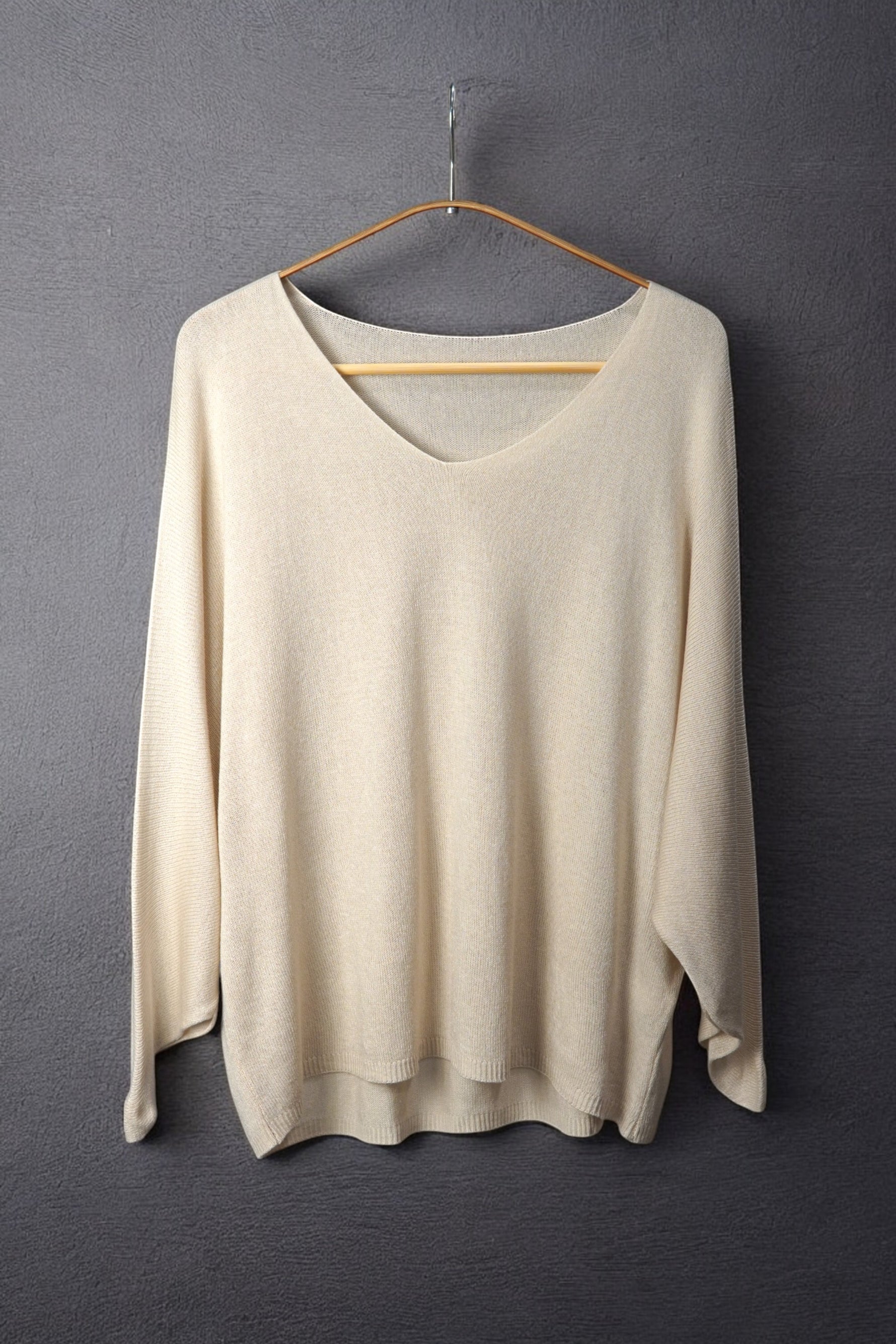 Bluză nude-bej din tricot fin, cu decolteu în V și croială vaporoasă, perfectă pentru un look soft și feminin.