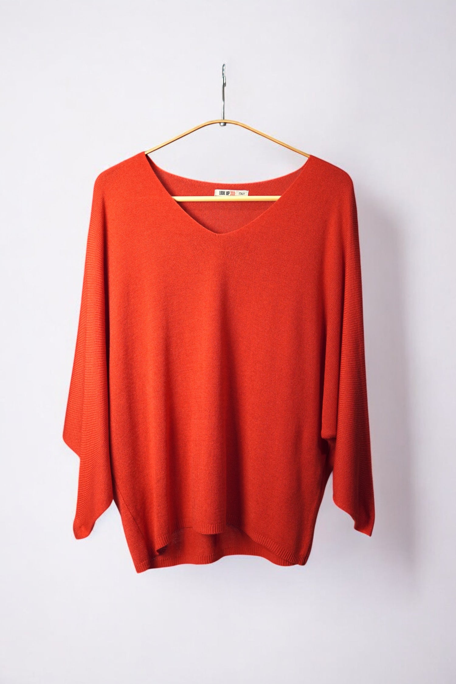 Bluză elegantă din tricot subțire în ton rosu corai, cu decolteu în V și design lejer.

