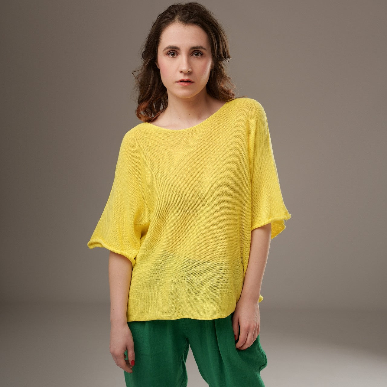 Bluză din tricot galben aprins, lejeră și confortabilă, combinată cu pantaloni verzi casual.