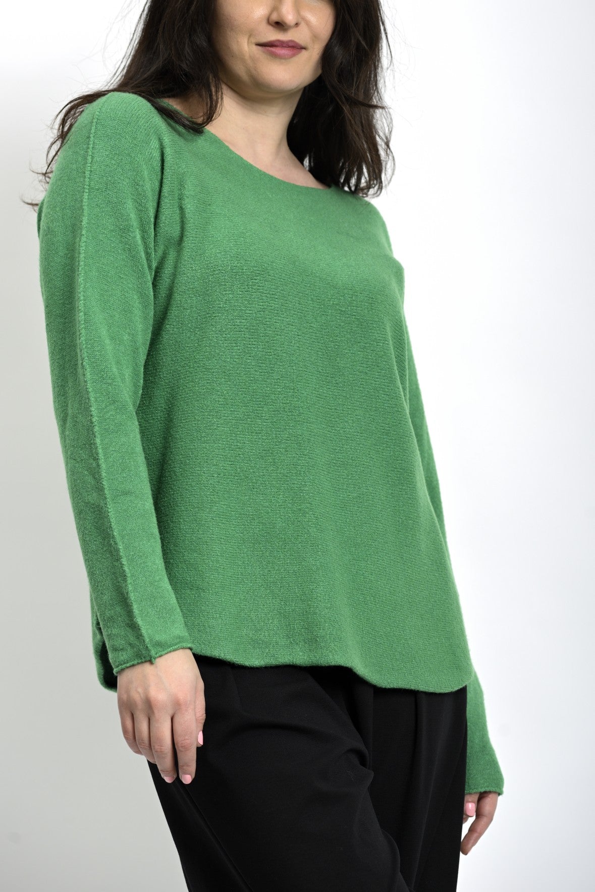 Vedere laterală a bluzei din tricot cu tiv rotunjit și mâneci lungi.