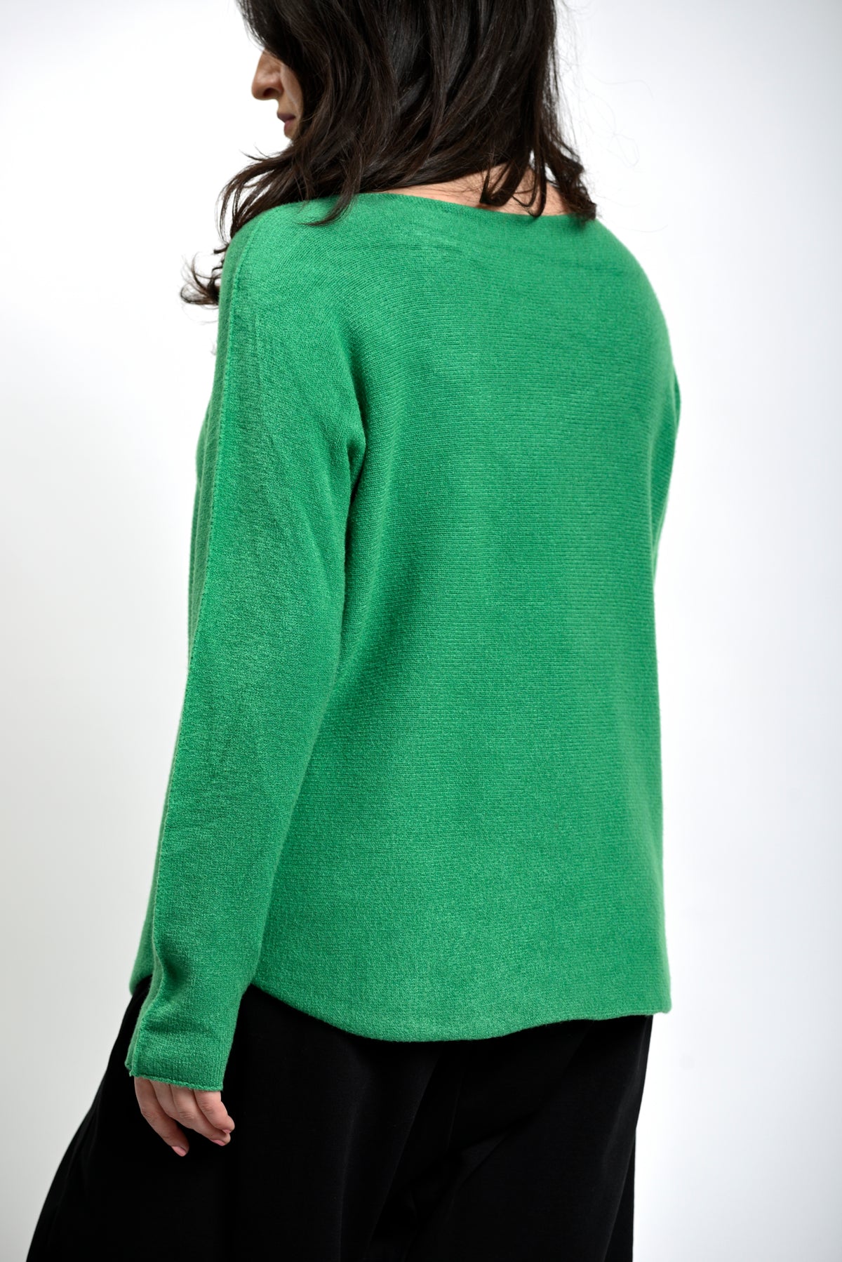 Spatele bluzei simple din tricot, cu cădere naturală și finisaj fără cusături vizibile.