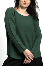 Bluză simplă din tricot verde, cu tiv rotunjit și croială lejeră, purtată cu pantaloni negri.