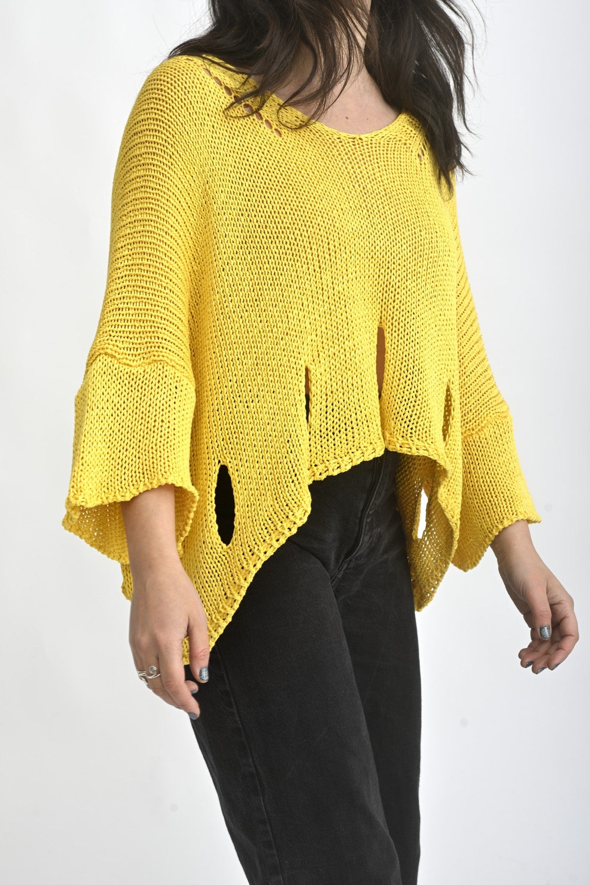 Detaliu mânecă largă al unei bluze galbene tricotate, cu finisaj lejer și aspect aerisit