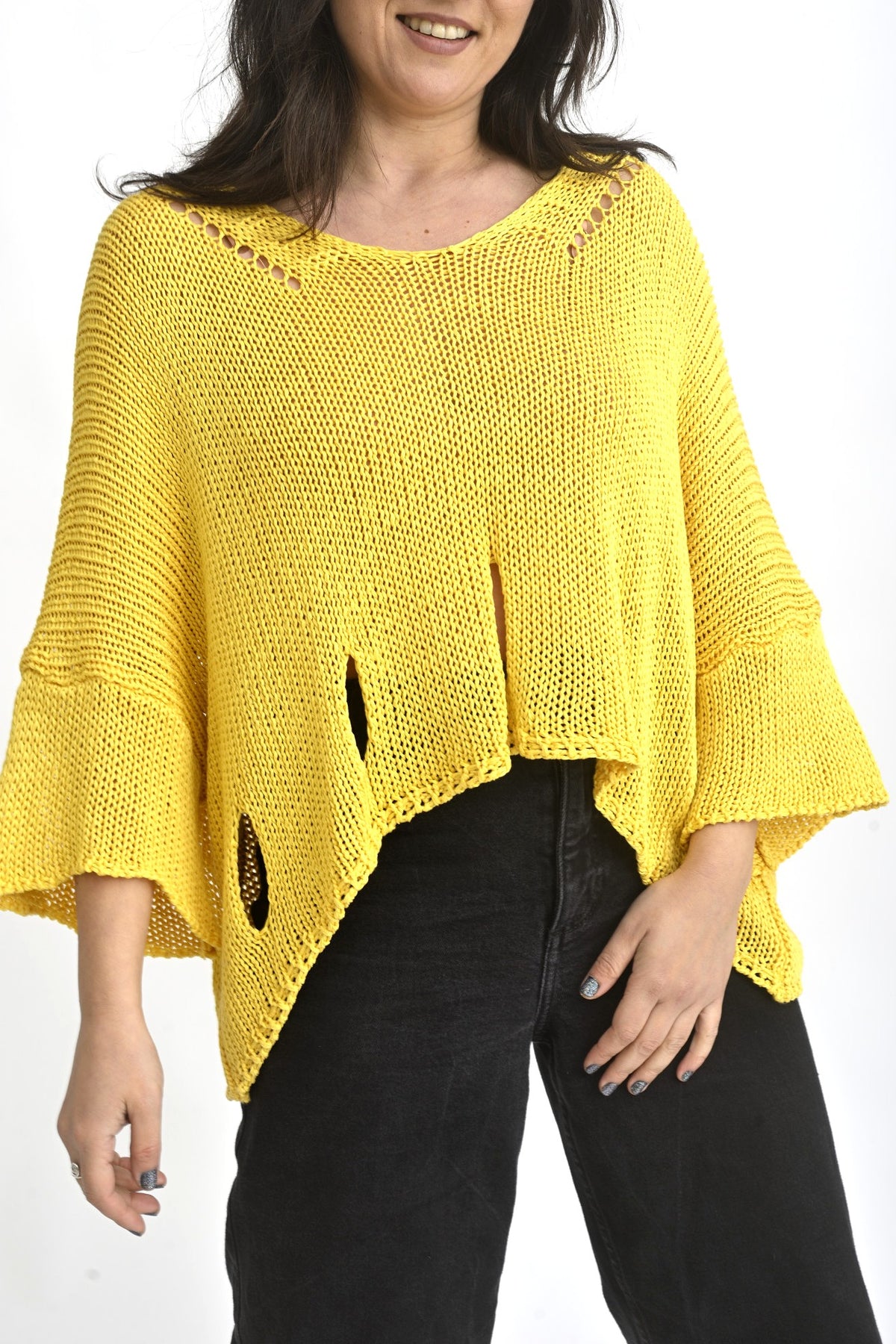 Detaliu textură tricotată aerată a unei bluze galbene cu rupturi decorative