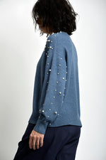 Bluză tricotată albastră cu perle aplicate pe umeri, design minimalist și croială relaxată.