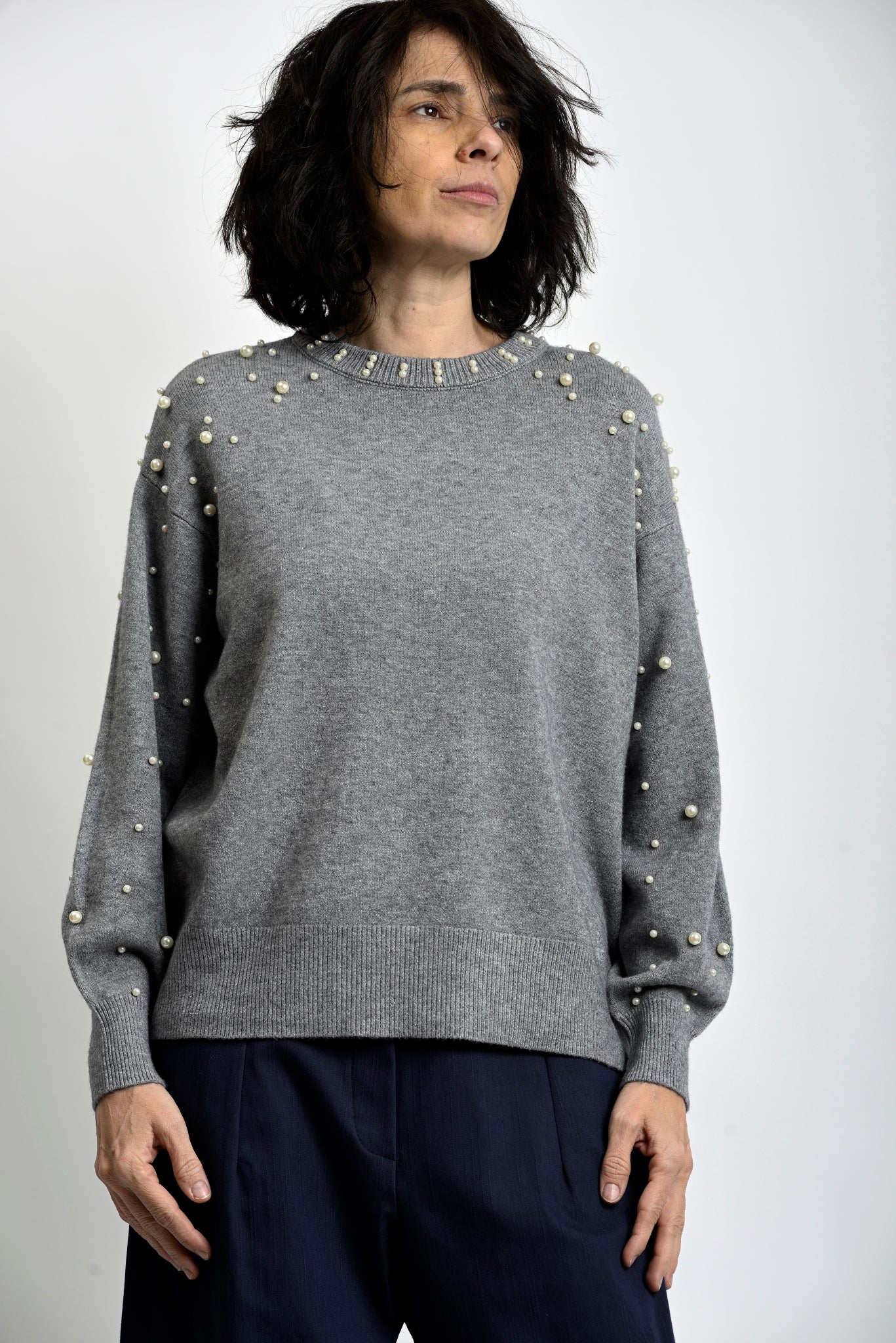 Bluză tricotată gri cu perle aplicate pe umeri și mâneci, croială lejeră și decolteu rotund.