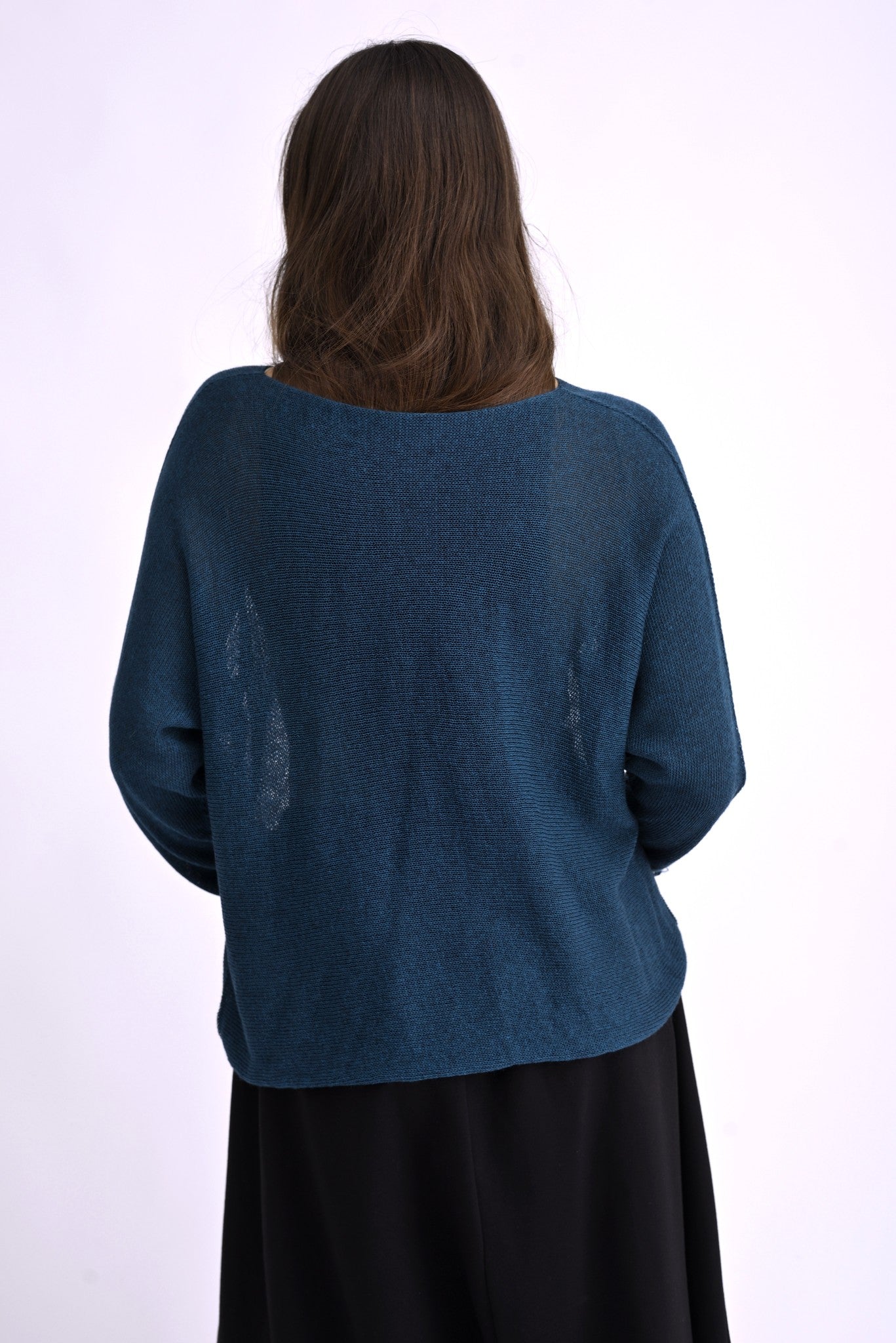 Bluza tricotată lejeră în nuanță turcoaz, vedere din spate, cu croială dreaptă și transparentă.