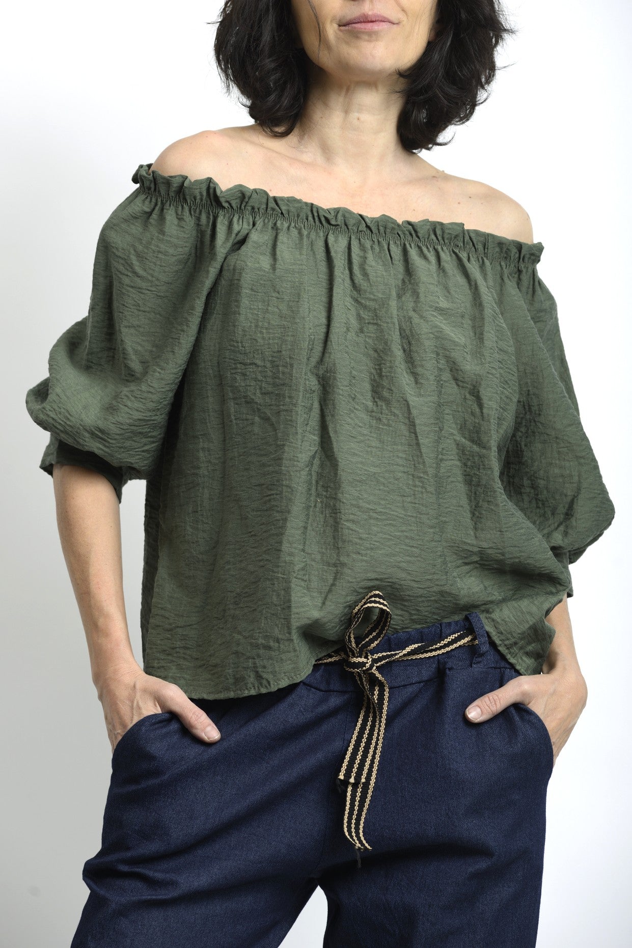 Bluză din vâscoză cu decolteu elastic și mâneci bufante, într-o nuanță verde, purtată lejer.