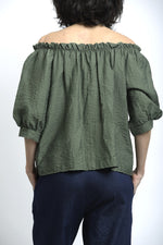 Spatele bluzei din vâscoză, cu decolteu elastic și cădere naturală.